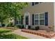 Charming home featuring blue shutters, decorative landscaping, and a welcoming front entrance with glass storm door at 2412 Chartwell Ln, Graham, NC 27253