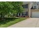 Charming two-story home featuring a well-manicured lawn, blue shutters, and an attached two car garage at 2412 Chartwell Ln, Graham, NC 27253