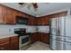 Well-lit kitchen showcasing stainless steel appliances and dark wood cabinets at 2412 Chartwell Ln, Graham, NC 27253