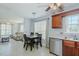 Open kitchen and dining area with stainless steel dishwasher and wood cabinetry at 2412 Chartwell Ln, Graham, NC 27253