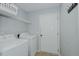 A well lit laundry room with a washer, dryer, and convenient shelving for ample storage at 2412 Chartwell Ln, Graham, NC 27253