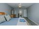 A comfortable main bedroom with wood laminate flooring, a ceiling fan, and a small pet gate at 2412 Chartwell Ln, Graham, NC 27253