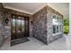 Covered entryway featuring a stone facade and elegant front door, creating a warm and inviting welcome at 2421 Beckwith Rd, Apex, NC 27523