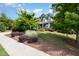 Beautiful landscaping surrounds a stone home with a two-car garage, creating a picturesque setting at 2421 Beckwith Rd, Apex, NC 27523