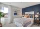 A stylish bedroom with unique decorations, an accent wall, and a large window showcasing the outdoors at 248 Alice Trace Place, Angier, NC 27501