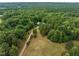 Aerial view of the property featuring a long driveway leading to a home surrounded by lush trees at 260 Woody Ln, Oxford, NC 27565