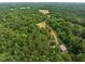 Overhead angle showcases the home nestled amidst dense woodland and the expansive driveway at 260 Woody Ln, Oxford, NC 27565