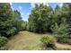 Large grassy backyard surrounded by mature trees and foliage providing a private oasis at 260 Woody Ln, Oxford, NC 27565