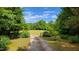 Scenic gravel driveway offers a picturesque approach, highlighting the property's natural beauty at 260 Woody Ln, Oxford, NC 27565