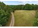 Scenic view of the large grassy field and a private gravel driveway at 260 Woody Ln, Oxford, NC 27565