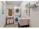 An organized laundry room featuring stacked washer and dryer and utility sink at 260 Woody Ln, Oxford, NC 27565