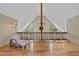 Spacious loft featuring hardwood floors, high vaulted ceilings, unique windows, and decorative railings at 260 Woody Ln, Oxford, NC 27565