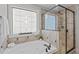 A relaxing bath with a patterned window above a large, tiled tub at 2712 Peachleaf St, Raleigh, NC 27614
