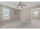 Bright bedroom featuring a ceiling fan, large window, and neutral carpet at 2712 Peachleaf St, Raleigh, NC 27614
