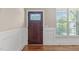 Elegant entryway with a dark wood front door featuring decorative glass, complemented by white wainscoting and hardwood floors at 2712 Peachleaf St, Raleigh, NC 27614