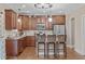 Well-appointed kitchen featuring rich wood cabinetry, stainless steel appliances, granite countertops, and bar seating at 2712 Peachleaf St, Raleigh, NC 27614
