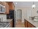 Kitchen with wooden cabinets, granite countertops, and hardwood floors leading to adjoining rooms at 2712 Peachleaf St, Raleigh, NC 27614