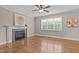 Cozy living room featuring hardwood floors, a fireplace with a stone surround, and a large window for ample light at 2712 Peachleaf St, Raleigh, NC 27614