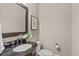 Stylish powder room featuring a dark granite countertop, elegant fixtures, and modern accents at 2712 Peachleaf St, Raleigh, NC 27614