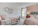 Charming bedroom with two twin beds, pink accent wall, large window, and cute decor at 272 Alice Trace Place, Angier, NC 27501