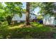 Spacious backyard with storage shed, white house, and a mix of grass and trees at 2725 Bedford Ave, Raleigh, NC 27607
