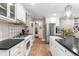 Kitchen features stainless appliances, black counters, white cabinetry, gas range and farmhouse sink at 2725 Bedford Ave, Raleigh, NC 27607