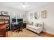 Functional office featuring a ceiling fan, large windows, and a comfortable sofa for a productive work environment at 2725 Bedford Ave, Raleigh, NC 27607