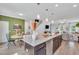 Open-concept kitchen featuring an island with bar seating, seamlessly flowing into the dining and living areas at 287 Alice Trace Place, Angier, NC 27501