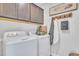 Bright laundry room with a modern washer and dryer, complete with upper cabinets at 287 Alice Trace Place, Angier, NC 27501