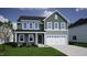 Two-story home boasts a tidy lawn, attached garage, and neutral siding under a blue sky at 294 Alice Trace Place, Angier, NC 27501