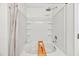 Bright bathroom bathtub features white tile surround, decorative accents, and modern shower head at 3040 Varcroft Rd, Knightdale, NC 27545