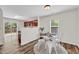 Bright dining area with modern table setting, wood floors, and adjacent kitchen space at 3040 Varcroft Rd, Knightdale, NC 27545