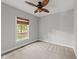 Bedroom with neutral carpet, ceiling fan, and a single window overlooking the yard at 308 Thomas Dr, Clayton, NC 27520