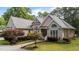 A brick house showcasing its manicured front lawn, landscaped garden, and a circular driveway at 308 Thomas Dr, Clayton, NC 27520
