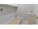 Bright laundry room with white cabinets, sink and neutral tile flooring at 308 Thomas Dr, Clayton, NC 27520