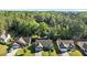 An aerial view of the homes with mature trees in the community that backs to a lake at 309 Coachman'S Trl, Stem, NC 27581