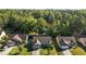 Aerial view of homes with mature trees in the community that backs to a lake at 309 Coachman'S Trl, Stem, NC 27581