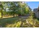 This expansive backyard features a deck, mature trees, and views of the nearby lake at 309 Coachman'S Trl, Stem, NC 27581