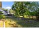 This spacious backyard features a deck, mature trees, and access to a lake at 309 Coachman'S Trl, Stem, NC 27581