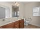 Bathroom with double vanity, framed mirror, toilet, and window for natural light at 309 Coachman'S Trl, Stem, NC 27581