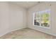 Bedroom featuring neutral paint, carpet, and a window overlooking the front yard at 309 Coachman'S Trl, Stem, NC 27581