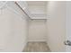 Walk-in closet with carpeted floor, built-in shelving and wooden closet rod at 309 Coachman'S Trl, Stem, NC 27581