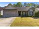 Charming single-story home with a two-car garage, stone accents, and well-maintained landscaping at 309 Coachman'S Trl, Stem, NC 27581