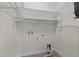 Functional laundry room with wire shelving and utility connections at 309 Coachman'S Trl, Stem, NC 27581