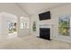 Open living room with a fireplace, large windows, and an open archway to the dining room at 309 Coachman'S Trl, Stem, NC 27581