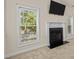 Cozy living room with a fireplace, large window, and wall-mounted television at 309 Coachman'S Trl, Stem, NC 27581