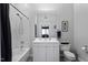 A well-lit bathroom featuring a shower-tub combo, updated vanity and neutral wall color at 319 Fayetteville St, Raleigh, NC 27601