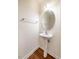 This half bathroom features an oval mirror, a pedestal sink, and modern fixtures at 3623 Landshire View Ln, Raleigh, NC 27616