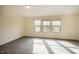 Bright bedroom featuring gray wood-look floors, three windows, and neutral paint throughout at 3623 Landshire View Ln, Raleigh, NC 27616