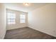 Neutral bedroom with wood-look floors, white trim, and two windows at 3623 Landshire View Ln, Raleigh, NC 27616